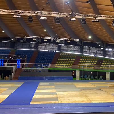 Allestimento di palco e pedane in un palazzetto dello sport con tribune vuote
