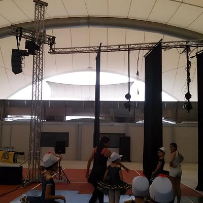 Preparazione di giovani ballerine per uno spettacolo di danza in tensostruttura con palco e impianto luci